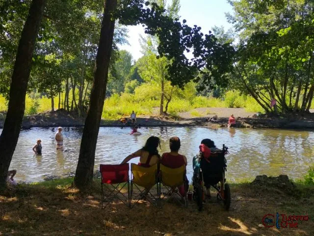 Pareja y familia disfrutando la orilla del río Laja en Camping El Girasol